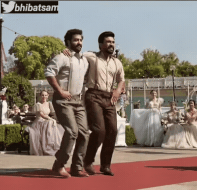Two Men Are Dancing On A Red Carpet With A Twitter Logo In The Background GIF