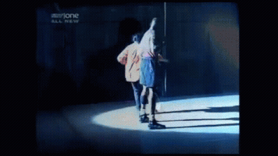 Two Men Are Dancing On A Stage In Front Of A Sign That Says Storyone GIF