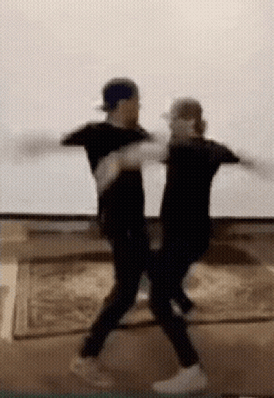 Two Men Are Dancing Together In A Living Room . GIF
