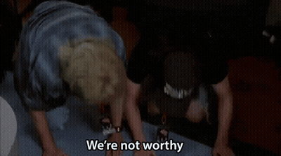 Two Men Are Dancing With Their Hands In The Air And One Of Them Is Saying We 'Re Not Worthy . GIF
