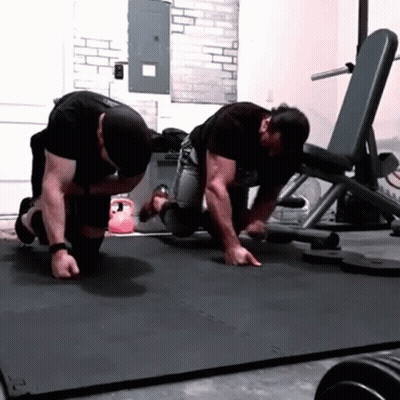 Two Men Are Doing Push Ups On A Mat With The Letter S On It GIF
