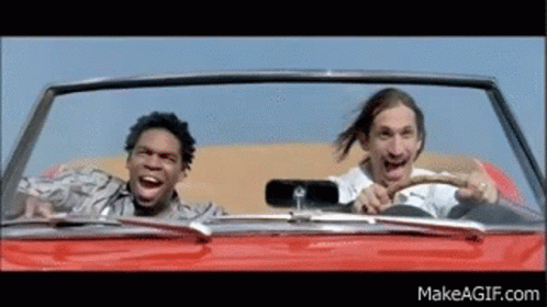 Two Men Are Driving In A Red Convertible And One Is Laughing GIF