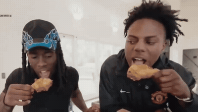 Two Men Are Eating Fried Chicken And One Is Wearing A Nike Shirt GIF