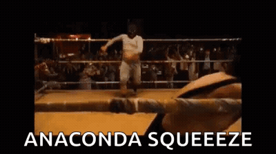 Two Men Are Fighting In A Boxing Ring And The Words `` Anaconda Squeeze '' Are Written On The Screen . GIF
