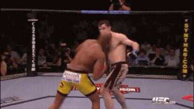 Two Men Are Fighting In A Boxing Ring . One Of The Men Is Wearing Yellow Shorts . GIF