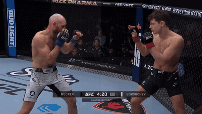 Two Men Are Fighting In A Boxing Ring With A Bud Light Banner In The Background GIF