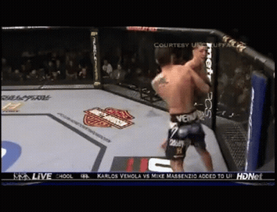 Two Men Are Fighting In A Boxing Ring With A Harley Davidson Logo On The Corner . GIF
