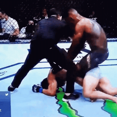 Two Men Are Fighting In A Boxing Ring With A Referee Watching . GIF