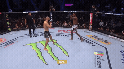 Two Men Are Fighting In A Boxing Ring With Ufc Written On The Floor GIF