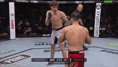 Two Men Are Fighting In A Cage With A Sign That Says Crypto.com In The Background GIF