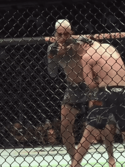 Two Men Are Fighting In A Cage With The Word Center Visible GIF