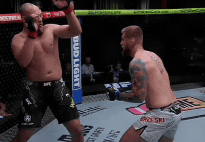 Two Men Are Fighting In A Ring With A Bud Light Sign In The Background GIF