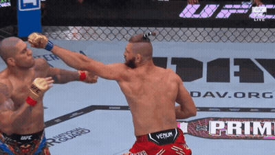 Two Men Are Fighting In Front Of A Sign That Says " Prime " GIF