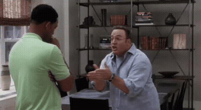 Two Men Are Having A Conversation In A Living Room . GIF