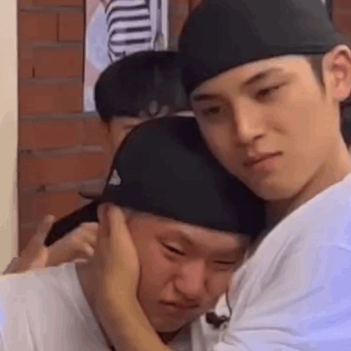 Two Men Are Hugging Each Other And One Of Them Is Putting His Hand On The Other 'S Ear . GIF