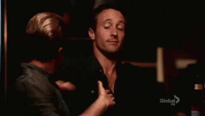 Two Men Are Hugging Each Other In A Dark Room And One Of Them Is Waving At The Camera . GIF