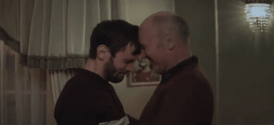 Two Men Are Hugging Each Other In A Room And One Is Holding The Other 'S Head . GIF