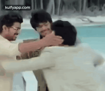 Two Men Are Hugging Each Other In Front Of A Pool . GIF