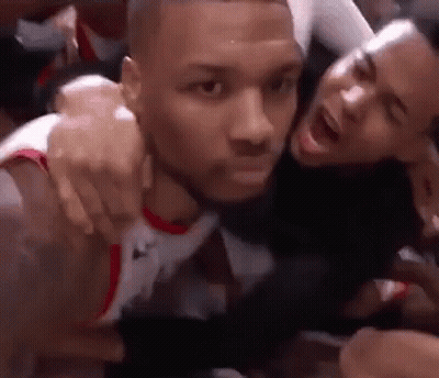 Two Men Are Hugging Each Other On A Basketball Court And One Is Screaming . GIF