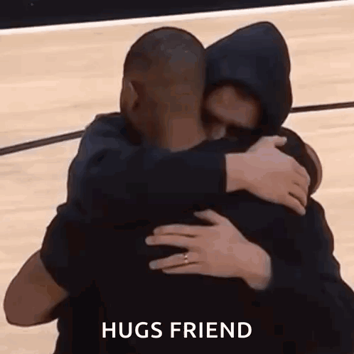 Two Men Are Hugging Each Other On A Basketball Court And The Words `` Hugs Friend '' Are Visible . GIF