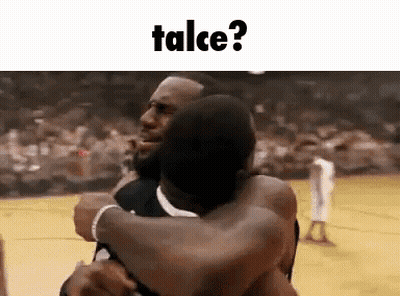 Two Men Are Hugging Each Other On A Basketball Court With The Words Talce Written Above Them . GIF