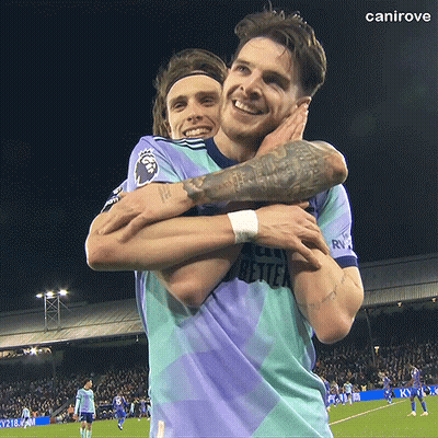 Two Men Are Hugging Each Other On A Soccer Field And One Has A Tattoo On His Arm GIF