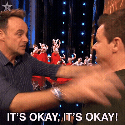 Two Men Are Hugging Each Other With The Words It 'S Okay It 'S Okay Behind Them GIF