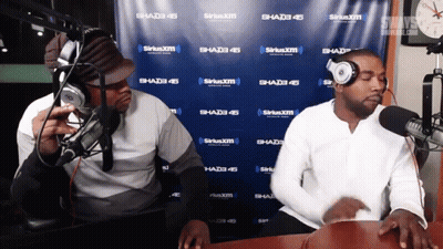 Two Men Are In Front Of A Siriusxm Wall GIF