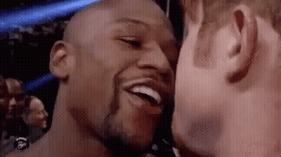 Two Men Are Kissing Each Other On The Cheek And Smiling . GIF