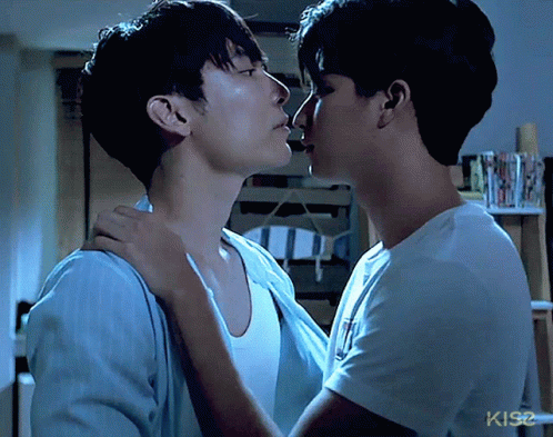 Two Men Kissing In Front Of KIS2 Sign GIF
