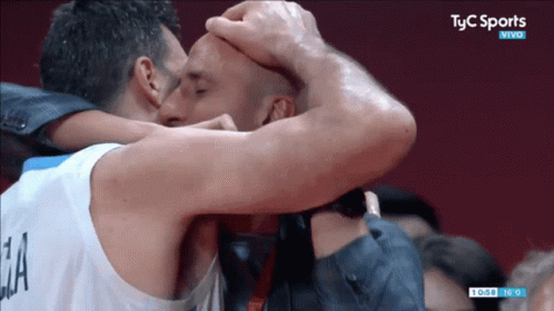 Two Men Are Kissing In Front Of A Tv Screen That Says Tyc Sports Vivo GIF