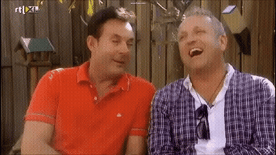 Two Men Are Laughing In Front Of A Sign That Says Rt Xl On It GIF