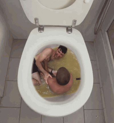 Two Men Are Laying In A Toilet With A Yellow Liquid GIF