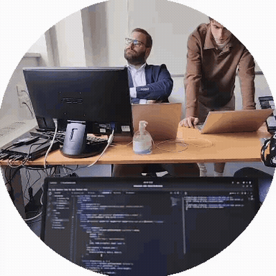 Two Men Are Looking At A Computer Monitor That Says Asus On It GIF