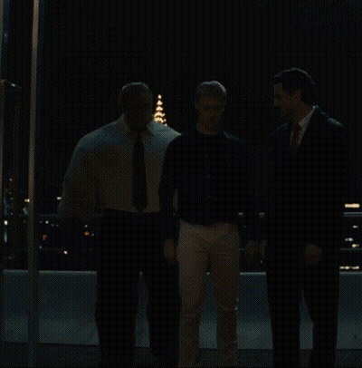 Two Men Are Looking At A Fireworks Display Over A City At Night GIF