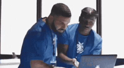 two men are looking at a laptop computer .