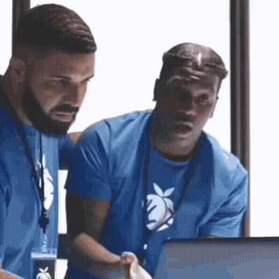 Two Men Are Looking At A Laptop Together . GIF