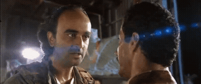 Two Men Are Looking At Each Other And One Has A Beard GIF