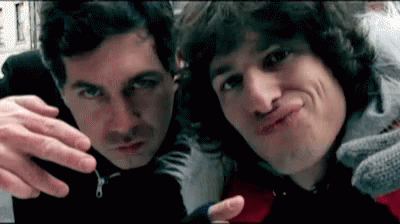 Two Men Are Making Funny Faces For The Camera While Standing Next To Each Other . GIF