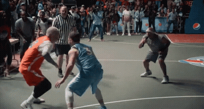 Two Men Are Playing A Game Of Basketball On A Court With A Crowd Watching . GIF