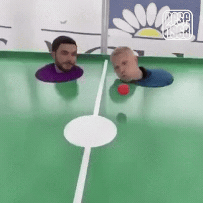 Two Men Are Playing A Game Of Pool With Their Heads In The Hole . GIF