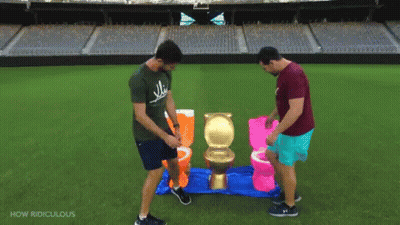 Two Men Are Playing A Game Of Toilets On A Field With The Words How Ridiculous Below Them GIF