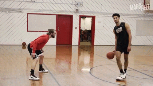 Two Men Are Playing Basketball In A Gym And One Has A Shirt That Says Oxford College GIF