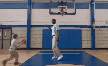 Two Men Are Playing Basketball In A Gym With A Sign That Says Exit On It GIF