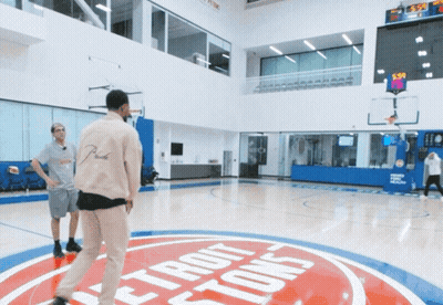 Two Men Are Playing Basketball On A Court With A Detroit Pistons Logo On The Floor GIF