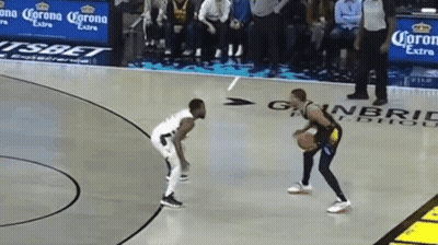 Two Men Are Playing Basketball On A Court With Corona Extra Advertisements On The Sidelines GIF
