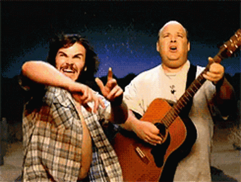 Two Men Are Playing Guitars And One Is Pointing GIF
