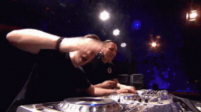 Two Men Are Playing Music In A Dark Room With Blue Lights Behind Them GIF