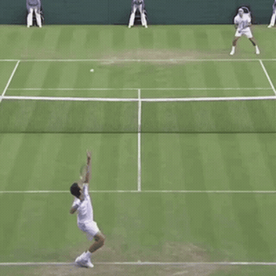 Two Men Are Playing Tennis On A Court And One Of Them Is Running Towards The Net GIF