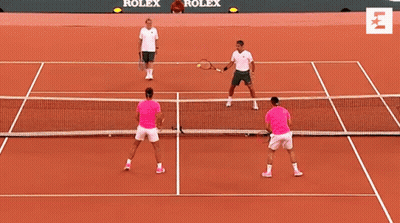 Two Men Are Playing Tennis On A Court With Rolex Advertisements On The Wall Behind Them GIF
